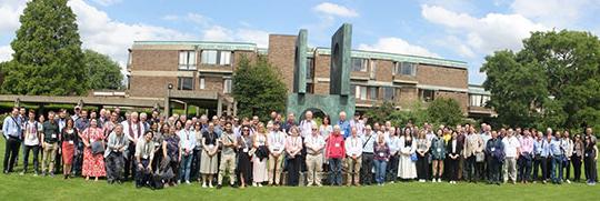 group of many people standing in front of a statue and building