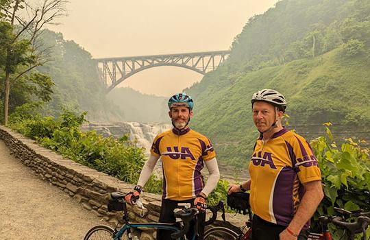 two men standing next to bicycles