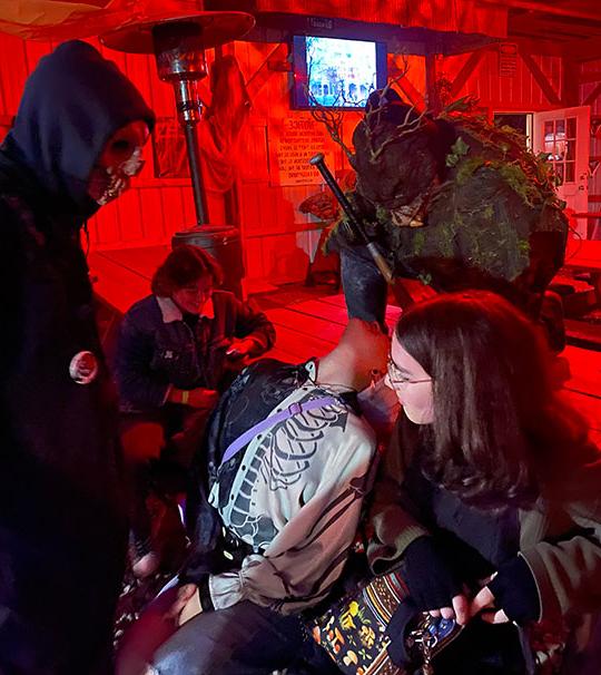 people sitting at a table with other people dressed up in scary costumes