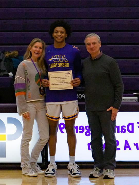 three people, one holding a certificate